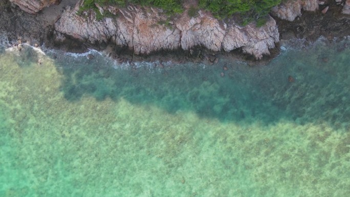 鸟瞰岛上原始的海岸线，碧绿的海水温柔地亲吻沙滩。这张迷人的照片捕捉到了海滨天堂的宁静和自然之美，郁郁