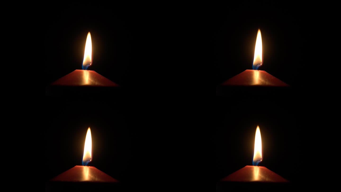 黑暗中蜡烛芯燃烧火焰的超级特写。