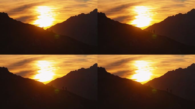 黄昏下降:两个徒步旅行者在山脊上下降的剪影