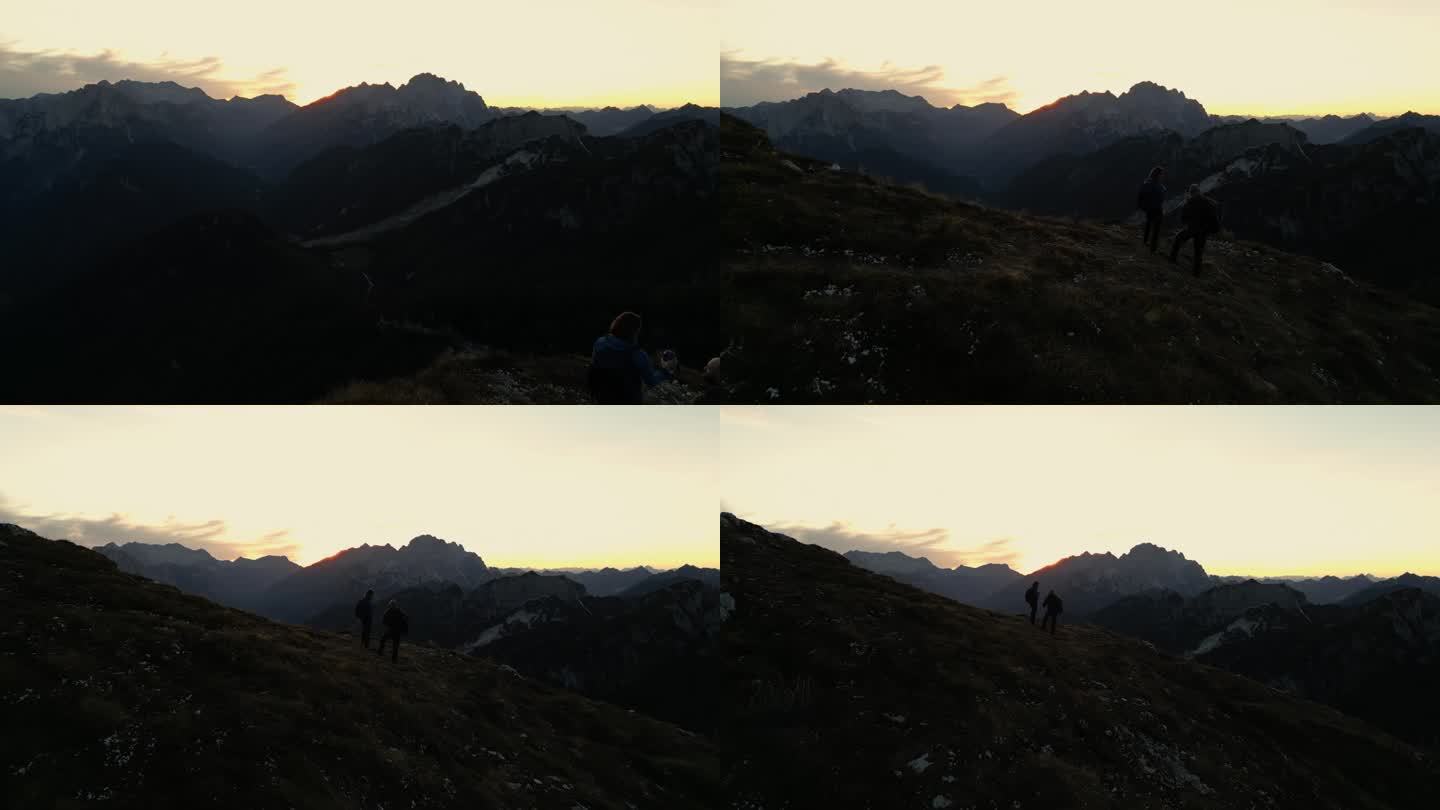 空中拥抱大自然的辉煌:徒步旅行者陶醉在黄昏的山脉威严