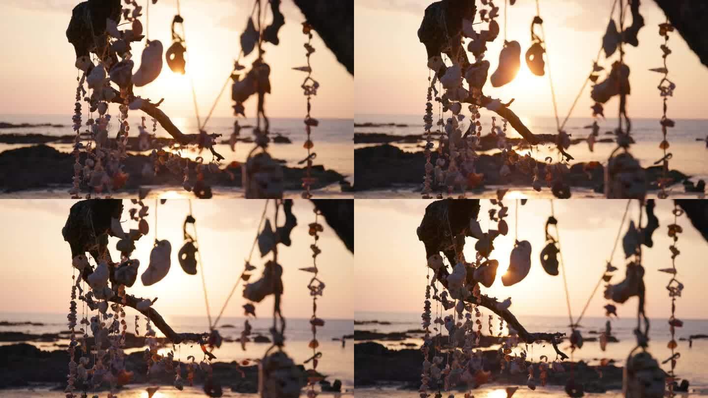 晚霞照耀着挂在泰国海滩上的珊瑚许愿树;幻灯片