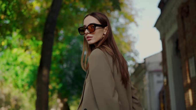 秋天的时尚展示就像女人的外套和眼镜走在城市的街道上