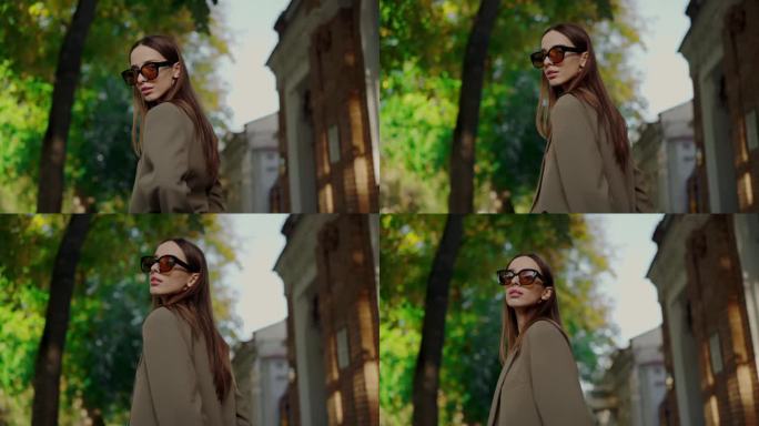 秋天的时尚展示就像女人的外套和眼镜走在城市的街道上