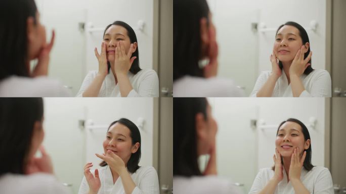 亚洲妇女在家里的浴室里护理她的面部皮肤