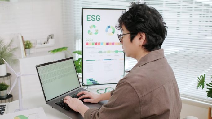 一位专注于NetZero排放计划、环境、社会和治理(ESG)数据的企业家，在环保的办公环境中使用笔记