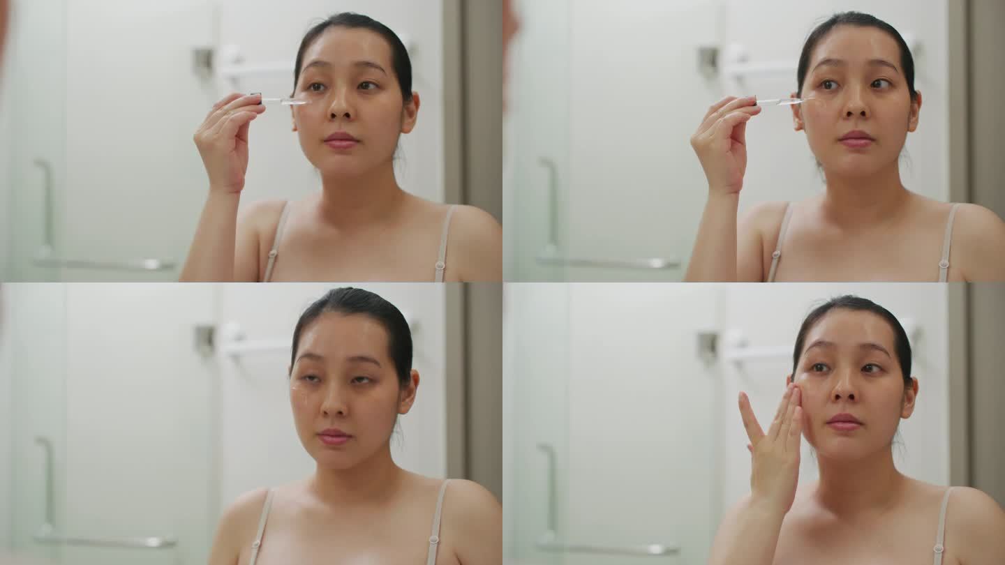 亚洲年轻女子在脸上涂抹精华液