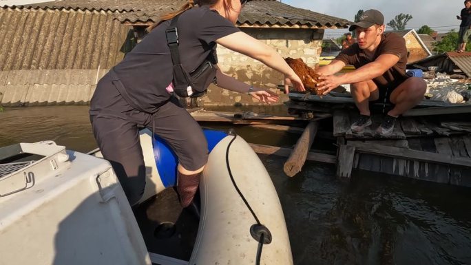 水电站爆炸后，志愿者乘船疏散鸡群。由于新卡克霍夫卡省第聂伯罗河大坝爆炸，赫尔松的房屋被淹。慢动作