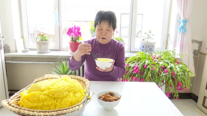 农村妇女在家里吃小米饭营养健康