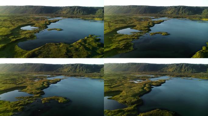 冰岛乡村一片宽阔的田野中间，雨水形成了一个湖泊，景色优美。