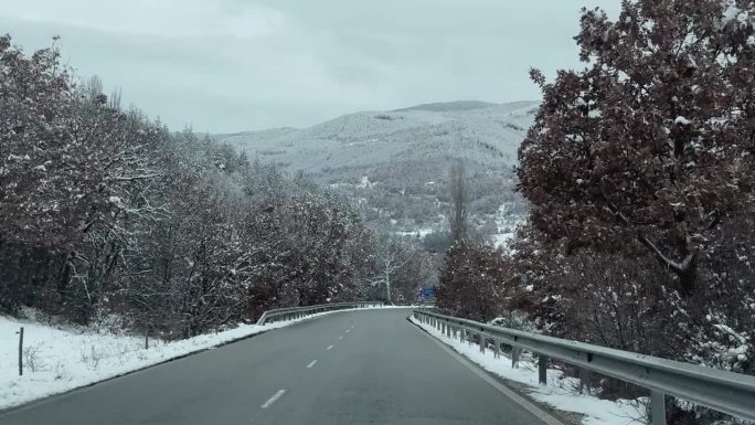 冬天开车在美丽的雪林山路上