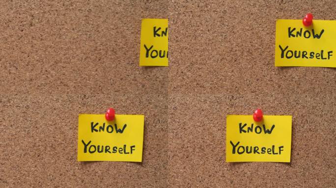 一张黄色的纸条，上面写着“认识你自己”，别在一块软木板上。