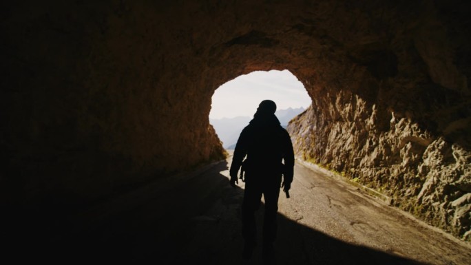 慢镜头进入光辉:孤独的徒步者征服山隧道