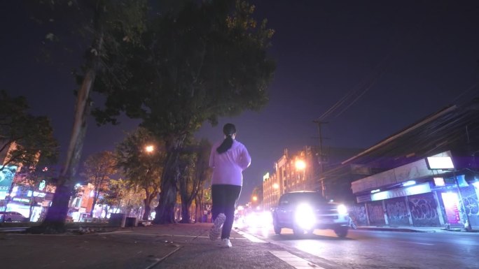 一名女子在夜间拥挤的城市街道上慢跑
