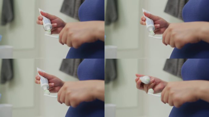 近照是一个女人用手在牙刷上挤牙膏