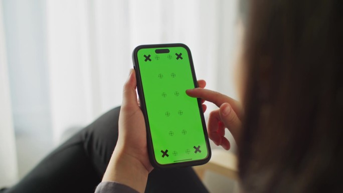 特写女性手使用绿色屏幕的智能手机