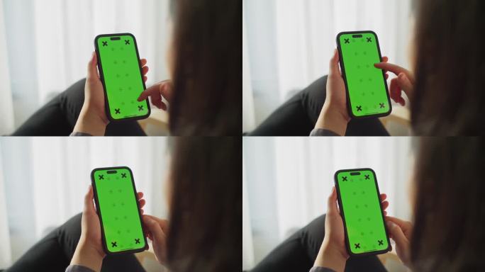 特写女性手使用绿色屏幕的智能手机