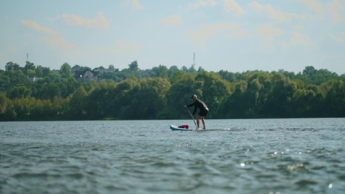 运动健将在河中立板漂流，暑假户外积极休闲