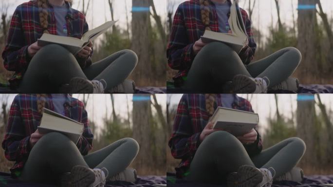 微笑的年轻女子读着圣经，写着笔记，欣赏着大自然