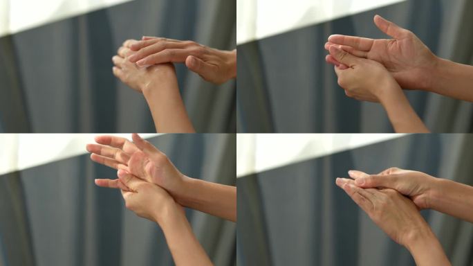 在这张剪短的照片中，一位中年亚洲女性在手上擦乳液霜，柔和的阳光照在她的手上。