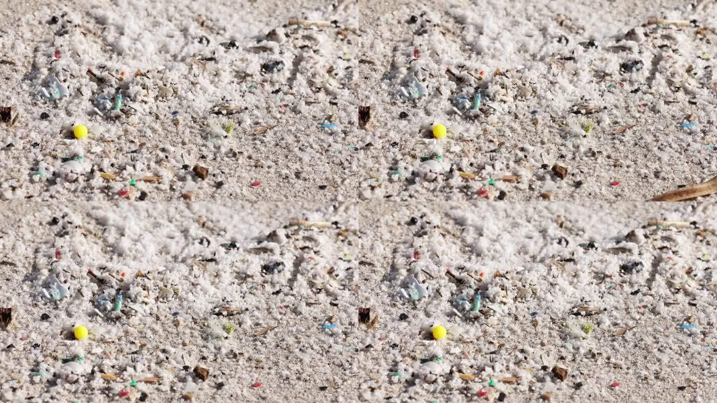 白天散落在沙滩上的微塑料和碎片特写
