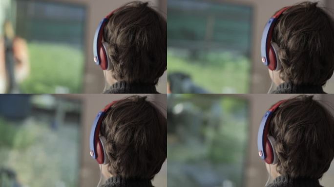 戴着耳机的男孩在主机上玩电脑多人视频游戏。儿童玩家在电视屏幕上玩电子游戏。戴着耳机和操纵杆的人在大电