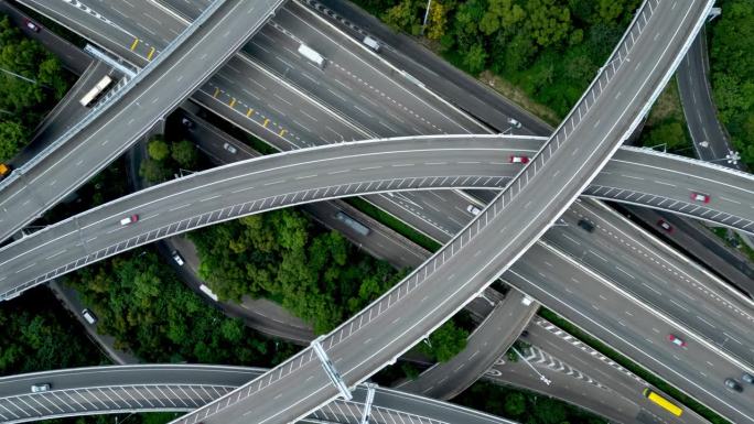 夏日城高速公路和通往美丽小镇的汽车路线的延时鸟瞰图。亚洲人乘巴士和卡车前往香港的概念。香港上空飞行全