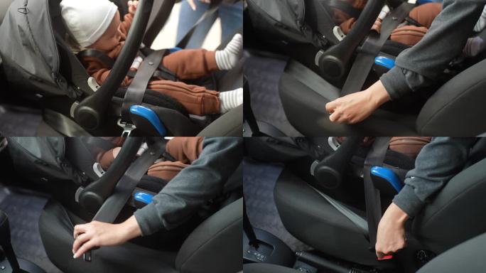 手持拍摄的无法辨认的母亲系安全带的婴儿男婴坐在前座背对发动机。车内系着安全带的可爱孩子。