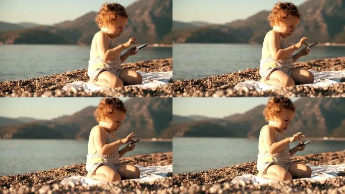 有趣的小女孩在海滩上的现代手机上滚动应用程序