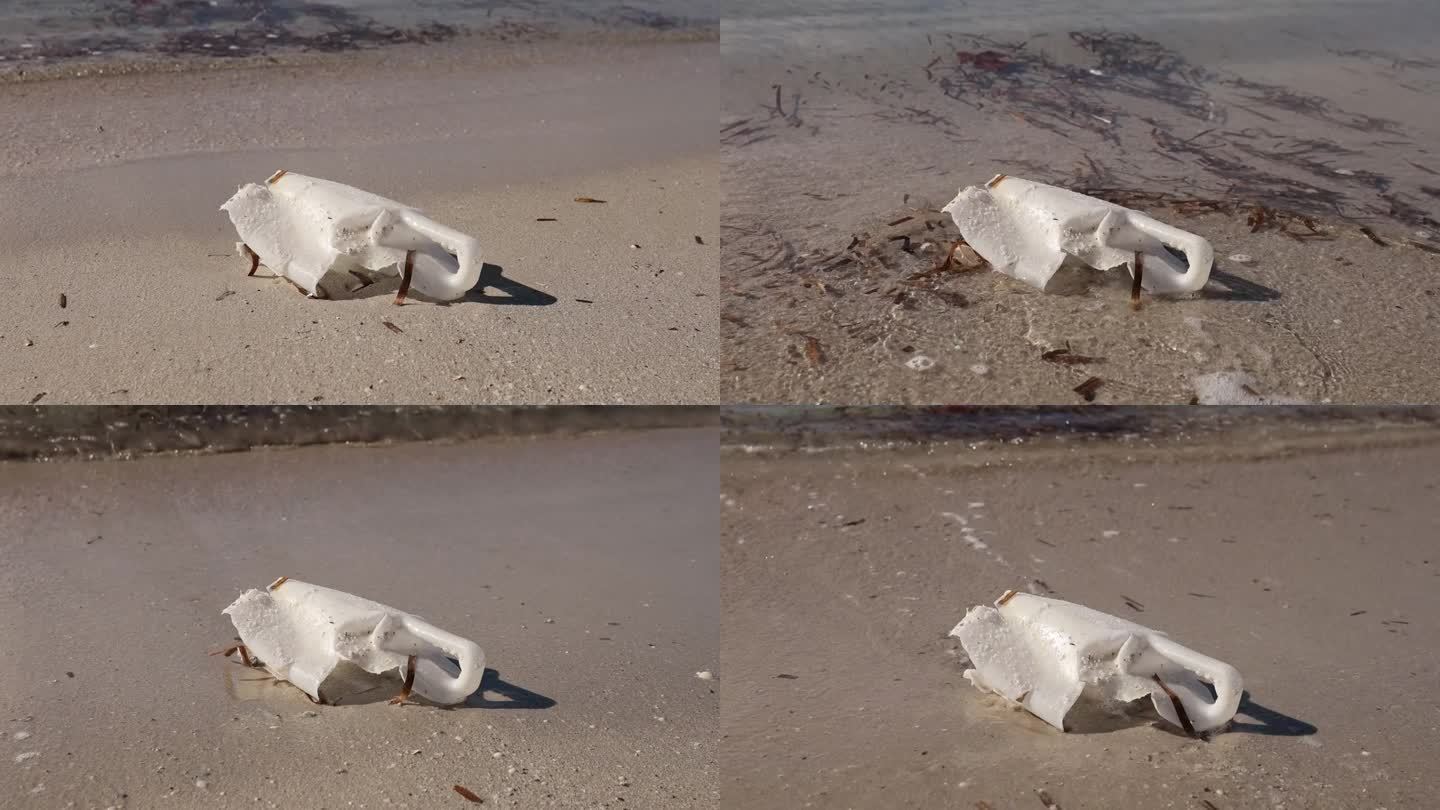 风化的塑料瓶散落在沙滩上，背景是海浪