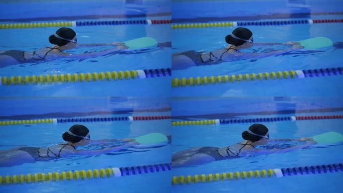 运动的年轻女子在游泳池游泳
