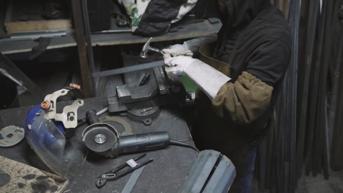 大师级的工匠在他的车间里用锤子加工金属制品