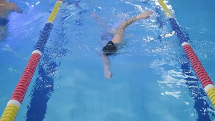 运动的年轻女子在游泳池游泳