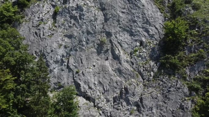 登山者挂在山上，镜头拉得很宽