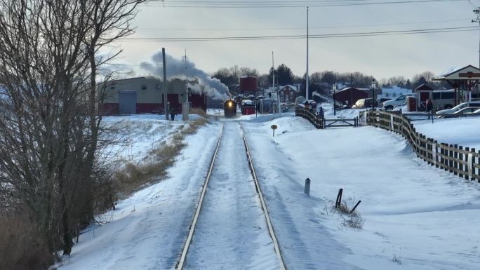 从鸟瞰图上看，一列火车正停在十字路口。来自斯特拉斯堡铁路的蒸汽随着汽车的驶过而来。交通和基础设施主题