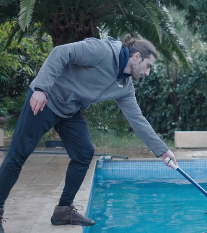白人潮人在冬天在传统的西班牙房子里打扫游泳池