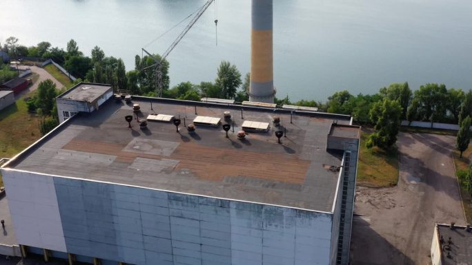 靠近水的有烟囱的工业建筑屋顶。