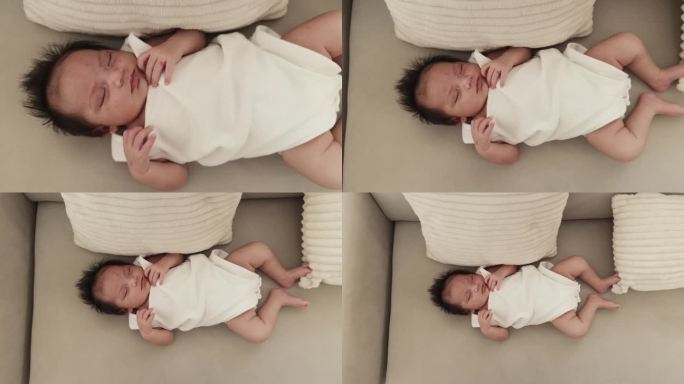 天真的幸福:舒适的新生女婴在沙发上小睡，唤起珍贵的家庭时刻的温暖和温柔。