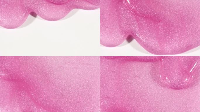 粉红色透明化妆品凝胶流体与分子气泡流动在白色的表面。微距镜头。液体乳霜凝胶透明化妆品样品纹理与泡沫。