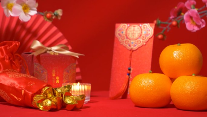中国农历新年的红色背景环。中国古代金条装丝袋，红包，红包，红包，有文字祝福的红色礼盒，橘子，纸扇，梅