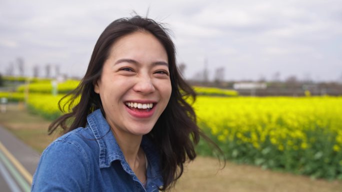 美女朋友开心的在春天的油菜花田快乐奔跑