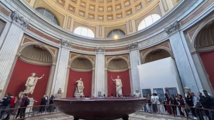 梵蒂冈城梵蒂冈博物馆圆形厅内雕像、大力神雕像和圆形单片斑岩盆附近的游客全景图