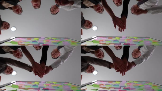 办公室里的团队合作:商务人员团结一致，双手堆叠成一个象征成就的手势