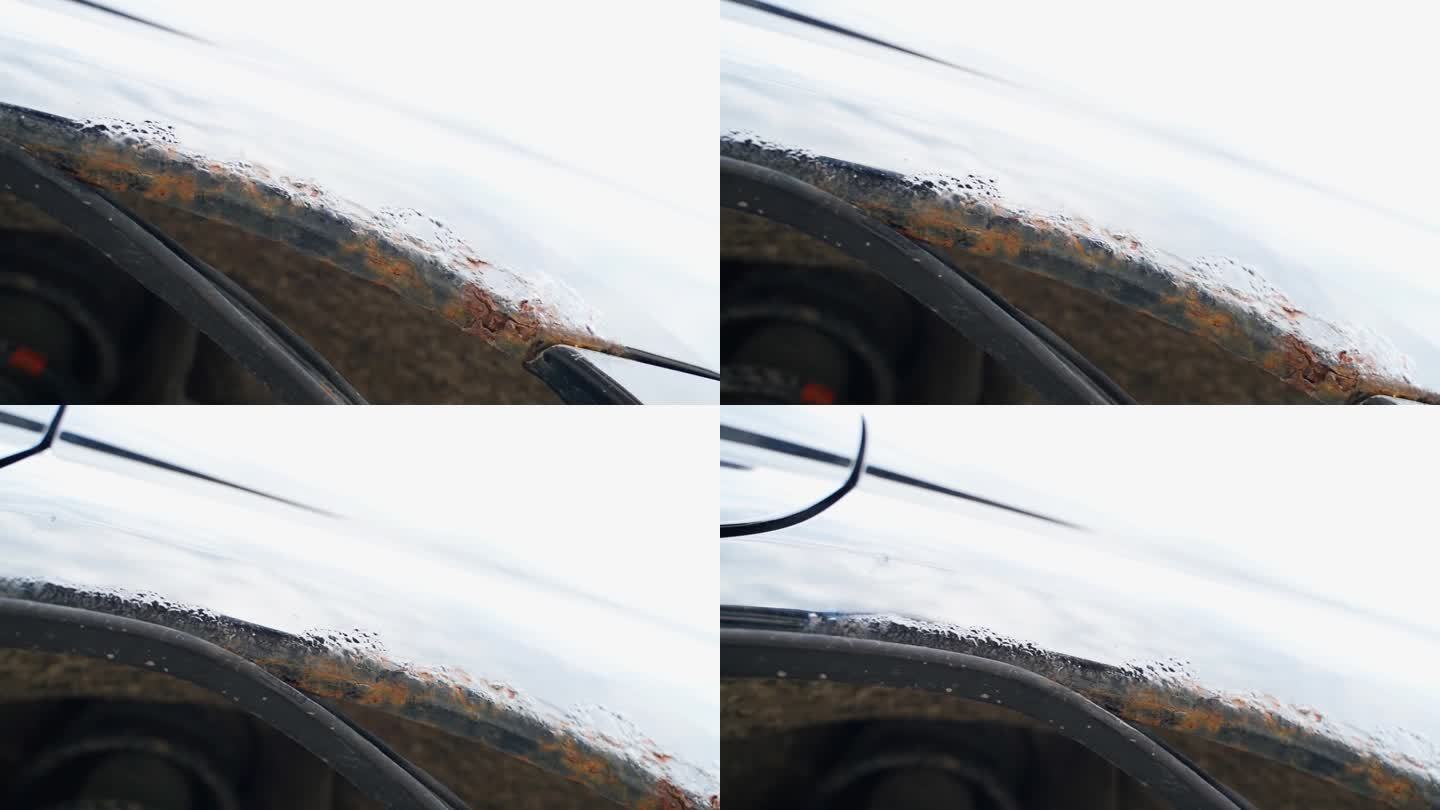 一辆黑色汽车的拱与通过腐蚀，底部视图。经过冬天，汽车的挡泥板被腐蚀了，橡胶密封件下面有湿气。试剂对车