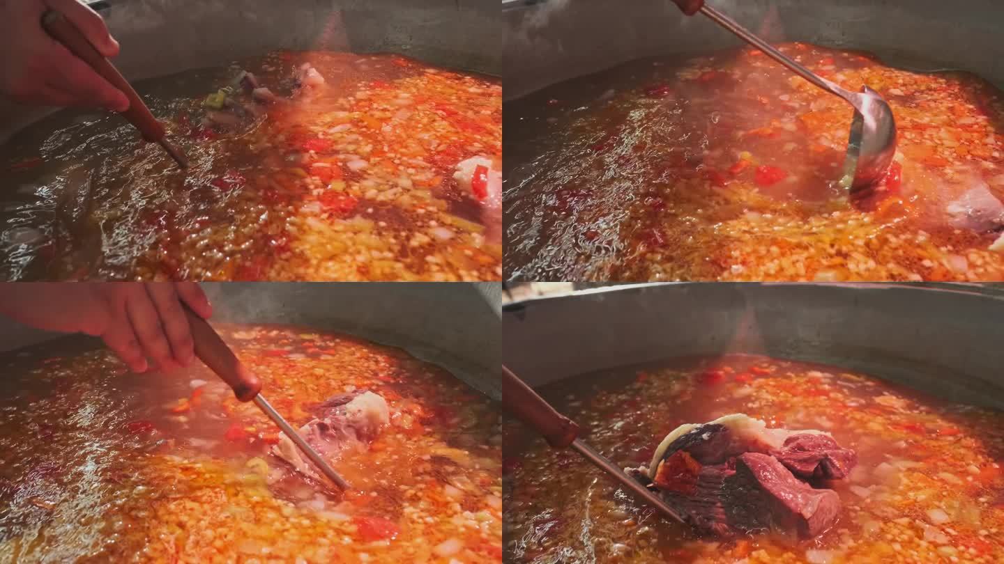 厨师用漏勺在大锅里拌肉汤和蔬菜