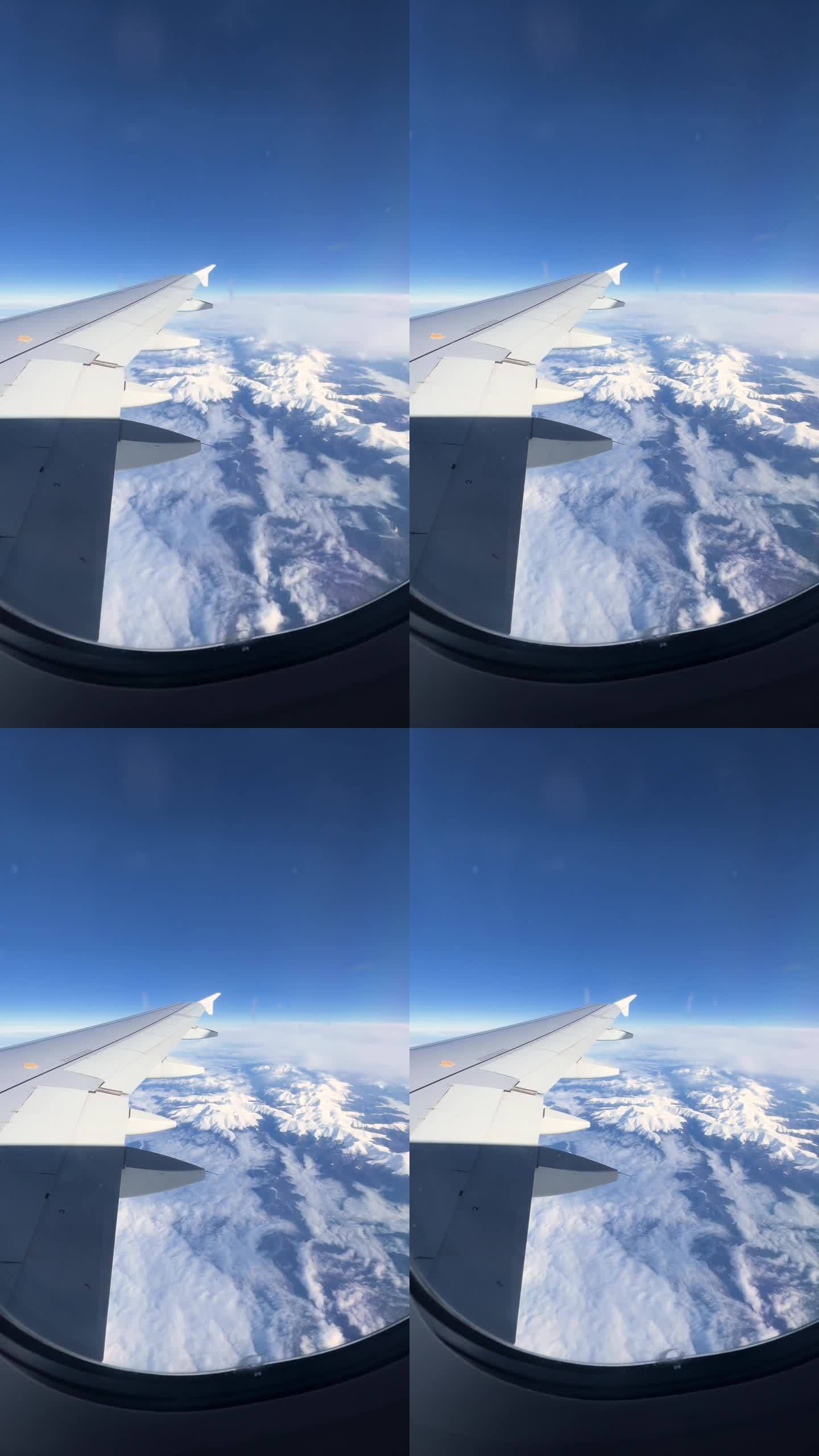 从飞机上看飞机的机翼和云，向窗外看美丽的山景，蓝天的景色，从飞机舷窗看天空和云