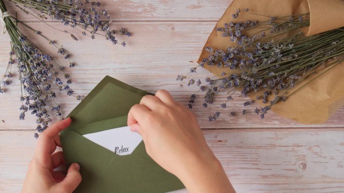 放松，刷新，充值文本在支持的信息纸笔记提醒绿色信封。平铺组成干薰衣草花。内心幸福的概念，放慢数字排毒
