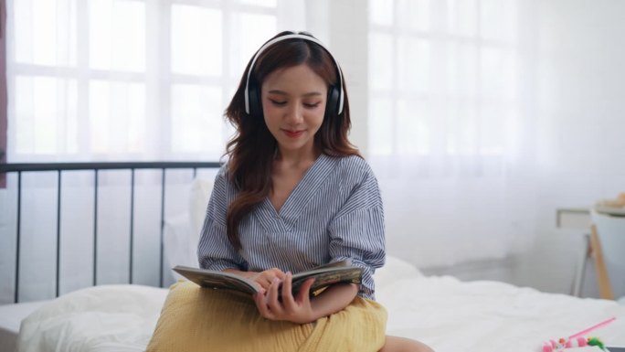 在阳光下的房间里，年轻的女士沉浸在阅读艺术杂志中，耳机音乐柔和