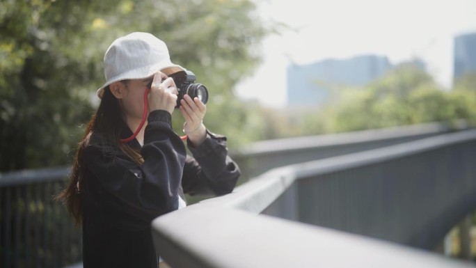 一个摄影师独自站着，用她的相机捕捉美丽的风景。