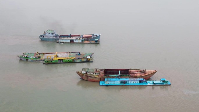 在孟加拉湾，锈迹斑斑的货船正被挖沙船填满