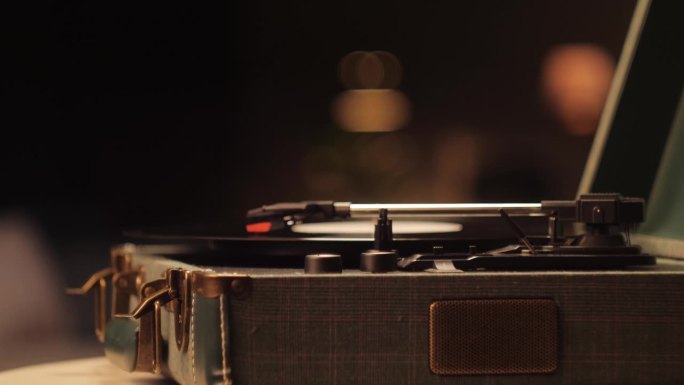 黑胶唱片特写。老式黑唱片旋转。复古音乐播放器在客厅的家庭背景在晚上。